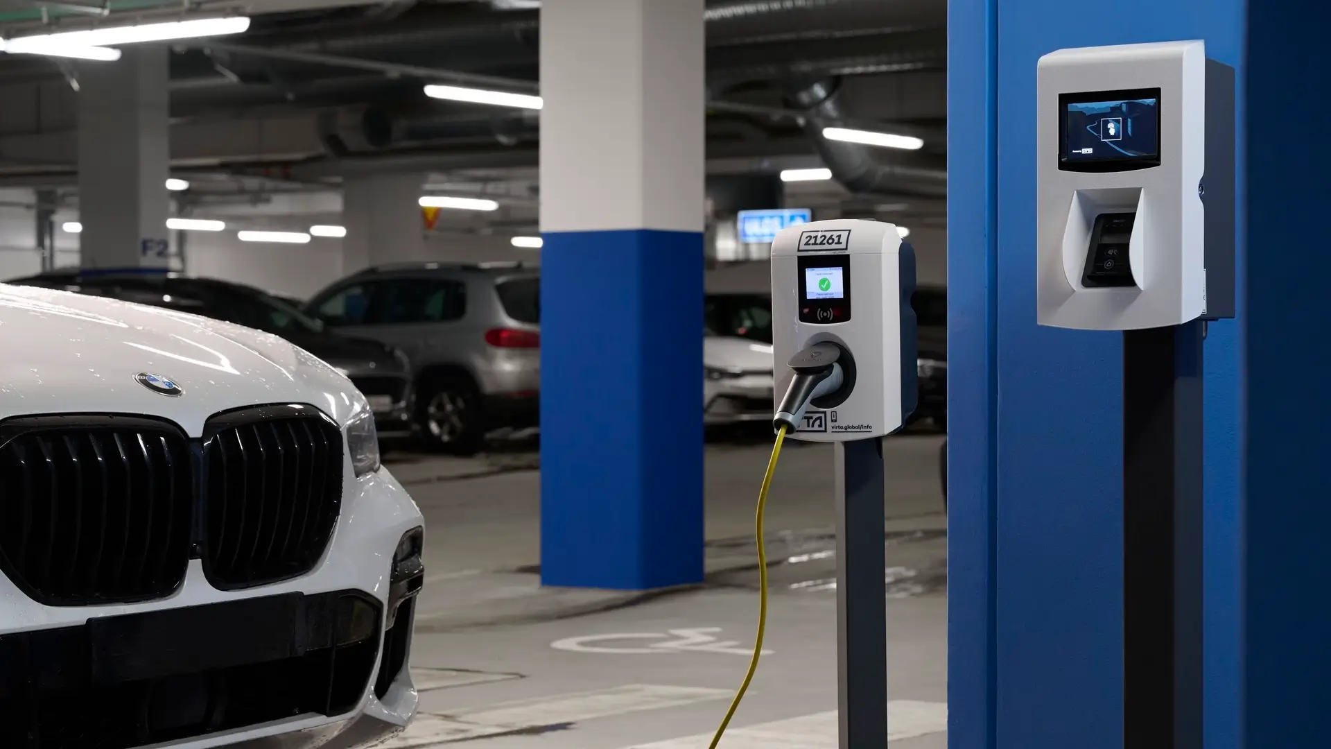 E-Laden in Parkgarage mit AC Ladestation und verbundenem Virta Payment Kiosk für Kartenzahlungen