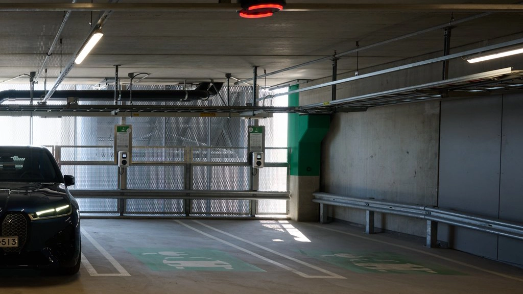 side of an indoor parking with one car and one empty spot 