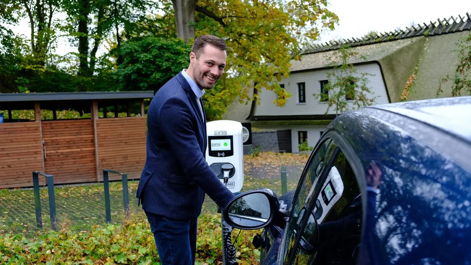 Man standing beside EV and AC charger