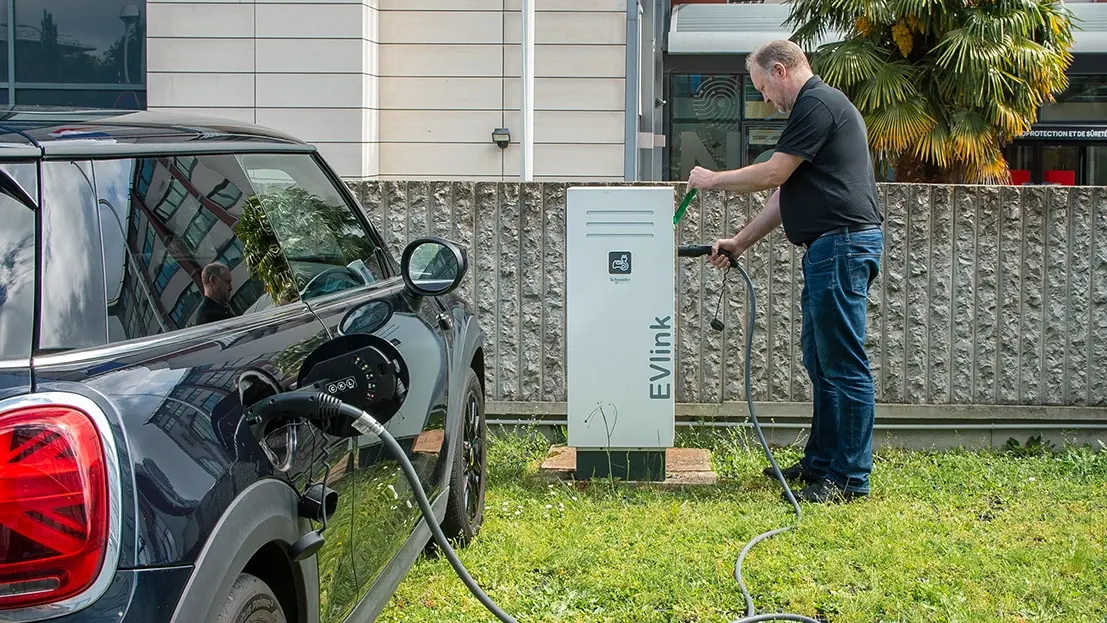 Man charging a black Mini Cooper