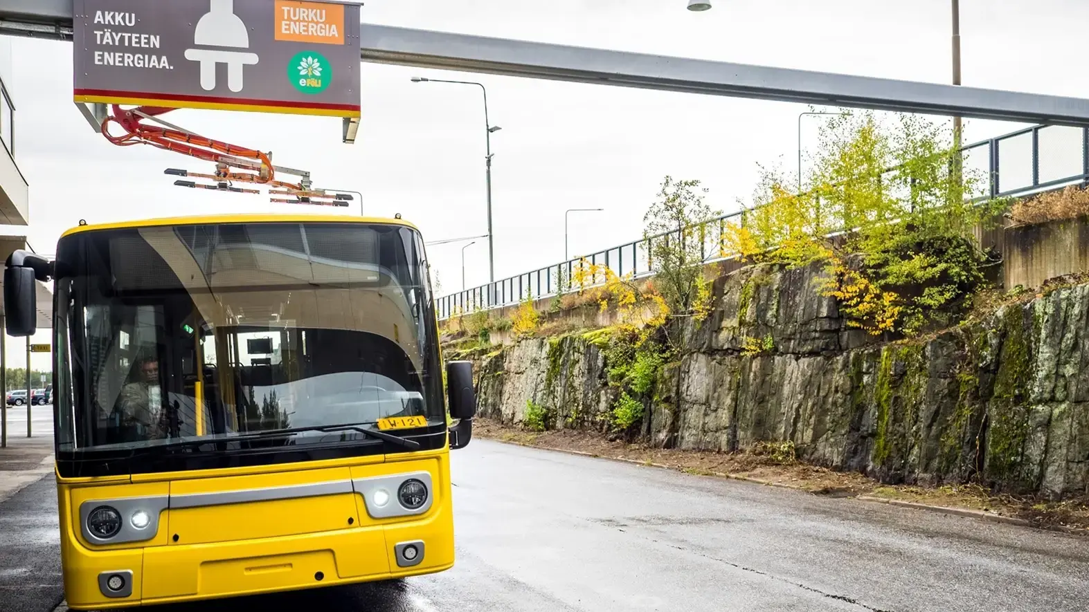 Yellow bus charging on a road